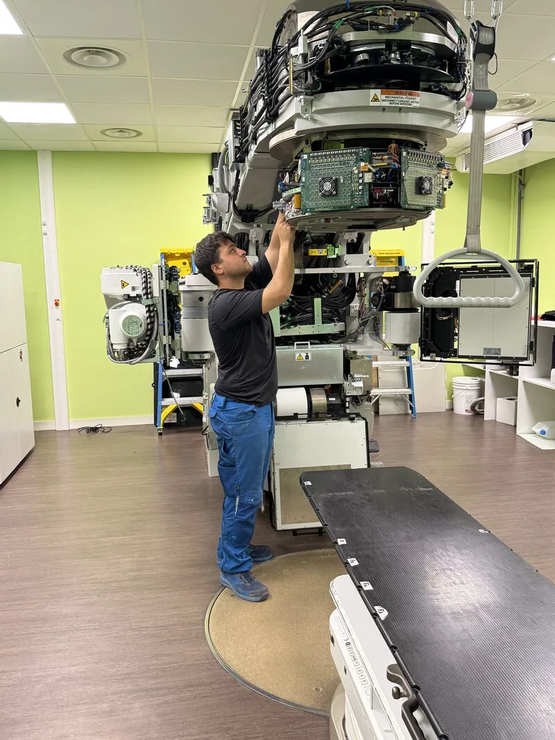Team member working on the exposed LINAC head — Hôpital Lyon Sud