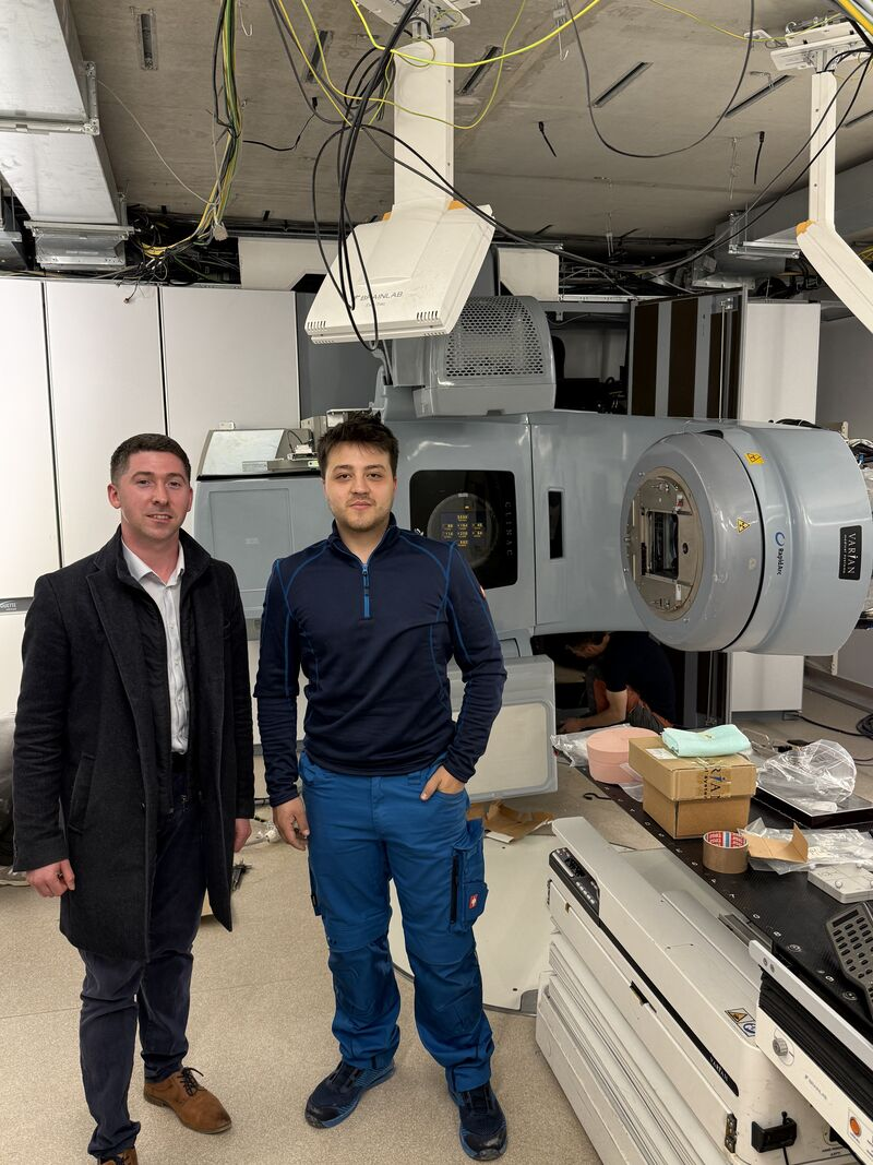 Project team beside the LINAC and patient table — Argenteuil