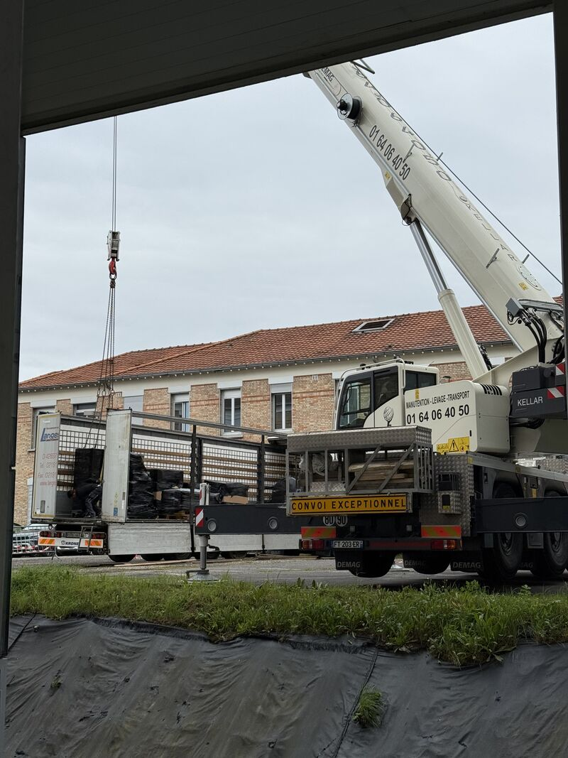 Crane and work area viewed through the open service doorway — Argenteuil