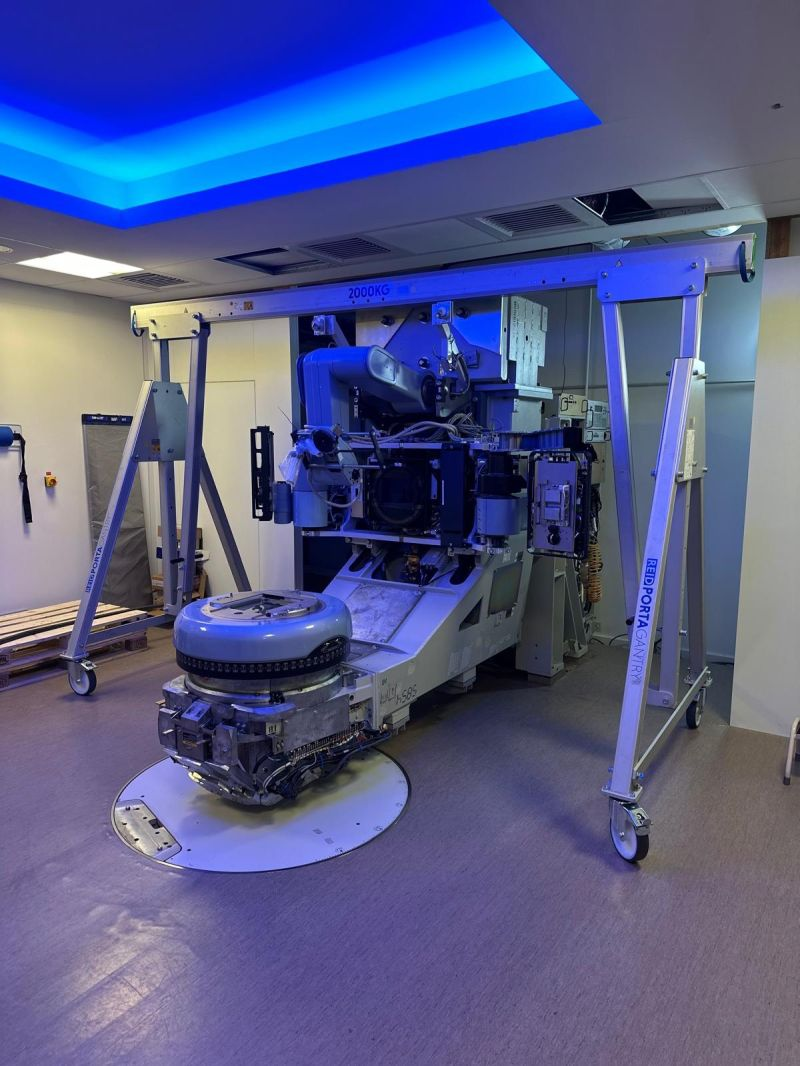 Lowered LINAC head in the blue-lit room — Carcassonne