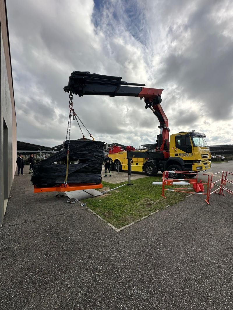 Wrapped unit being moved by crane in the outdoor work area — Carcassonne