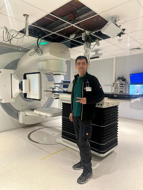Project team beside the LINAC and patient table — Saint-Luc